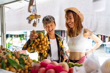 Group of Happy Asian people tourist buying and eating street food with using mobile app on smartphone scan QR code making online payment during travel local town in Thailand on summer holiday vacation