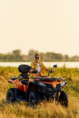 Portrait of a smiling woman driving a rented quad bike, with sunglasses on. © bnenin