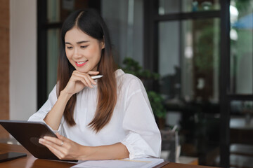 Fototapeta premium Businesswomen reading data on tablet and thinking about new startup while working in outside office