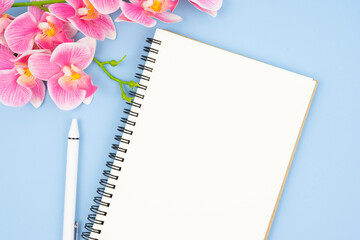 The Blank open notebook and pen with pink color orchid for your text or message.