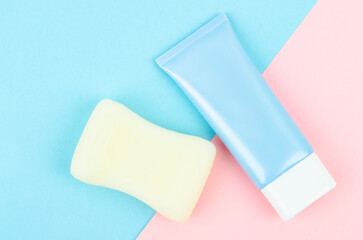 Top view of blue squeeze bottle plastic tube and herb soap bar on beautiful background for branding of medicine or cosmetics.