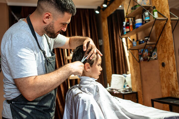 Toddler getting new haircut at the barber shop
