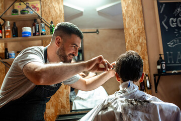 Little boy at the hairdresser getting new haircut 