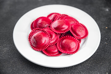 ravioli red color beet dye radicchio and meat filling smoked ham Cooking appetizer meal food snack on the table copy space