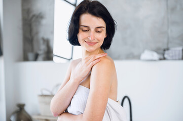 Woman touching soft healthy body skin after hydrating lotion or cream