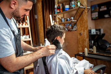 Barber brushing cut hair from the boys neck