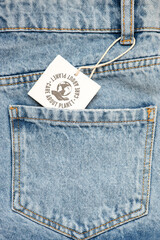 Product recycling concept. Organic cotton recycled fabric, zero west, materials. Jeans pocket with  recycling icon show on tag.