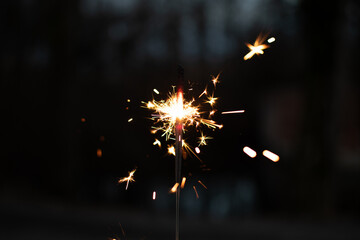 Obraz premium photography, sparkler close-up on a dark background, holiday lights 