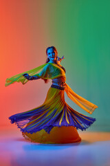 Indian culture. Beautiful woman in elegant dress dancing traditional indian dance against gradient...