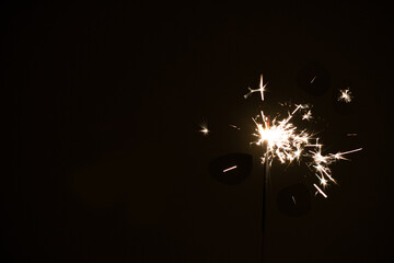 photography, sparkler close-up on a dark background, holiday lights