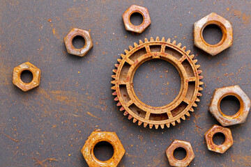 old rusty gear wheel and bolts on black background