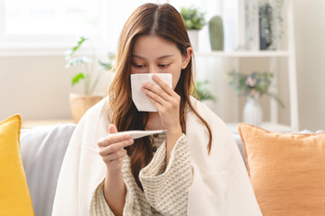 Woman measuring temperature her body on the bed. person got fever lying on the bed.