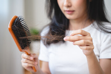Close-up young woman brushing her hair and have many hair loss on the comb