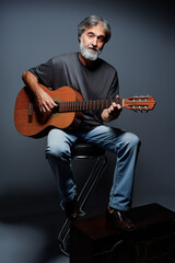 Aged bearded man with an acoustic guitar