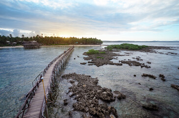 Fototapeta na wymiar Beautiful landscape. Sunset on the seashore. Wooden bridge on Cloud Nine beach, Siargao Island Philippines.