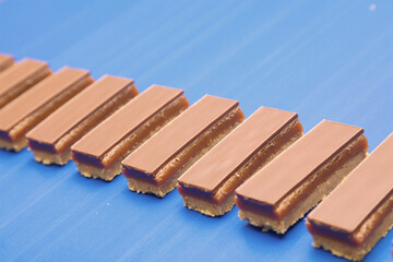 close up picture of caramel shortbread on a conveyor belt