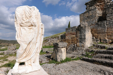 Headless statue wearing a toga, Roman ruins of Segobriga, Spain - obrazy, fototapety, plakaty