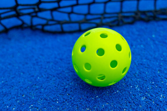 Ball of pickleball in front of the net, racket sports concept