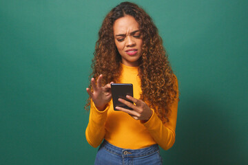 Young woman reads text message, disappointed confused, green studio background
