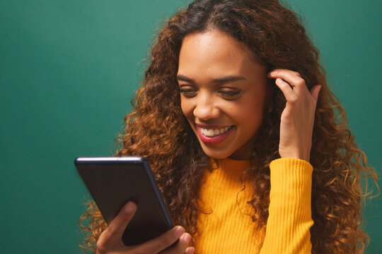 Beautiful young woman texts boyfriend, flirty message relationship, green studio