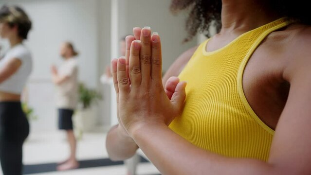 Woman holding hands in namaste gesture during yoga workout