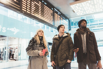 Three young multiethnic friends at railway station