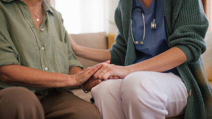 Obraz premium Close-up of nurse holding hand to senior client.