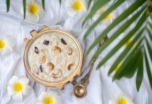 Top view of Payasam with flowers, Onam sweets dessert semiya payasam also known as Khir payasam in a golden vessel