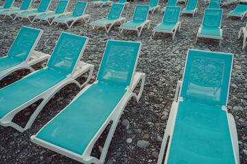 Turquoise blue sun loungers on the beach. Summer vacation at sea. Rusty beaches. All inclusive. Sunbathing. High quality photo