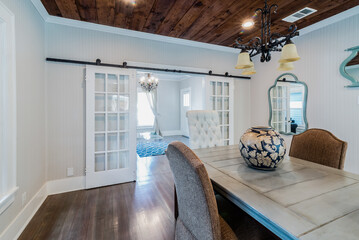 Dining Room with Shiplap Ceiling, French Doors, and Wood Table in Vintage Home