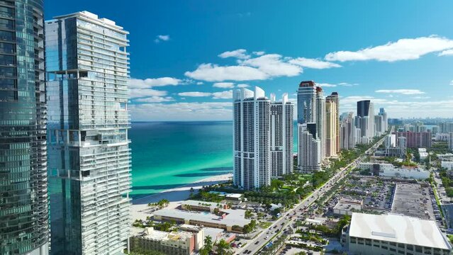 Aerial view of Sunny Isles Beach city with congested street traffic and luxurious highrise hotels and condos on Atlantic ocean shore. American tourism infrastructure in southern Florida