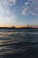 Fototapeta na wymiar View of bosphorus strait water at sunset with low light and bridge with skyline