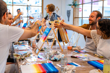 Painting Workshop. Friends toasting happily with glasses of wine in a painting workshop. - Powered by Adobe