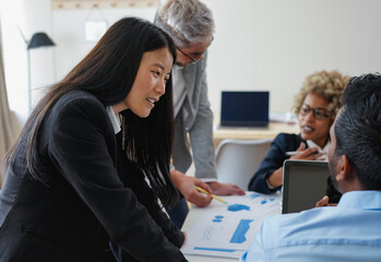 Team of multiracial business people working together inside modern office while sharing ideas during brainstorm meeting