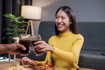Asian man and woman couple happily eating together inside their home celebrating the weekend.