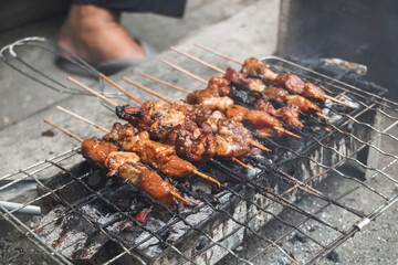 Top view of Sate or satay, traditional food from Indonesia is being grilled on fiery charcoal.