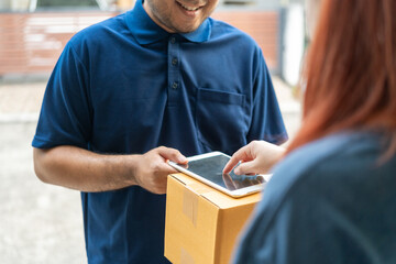 Delivery man holding cardboard boxes. Hand female accepting a delivery boxes of paper containers. Woman sign in tablet or mobile phone after receiving parcel from courier. Signing to get package.