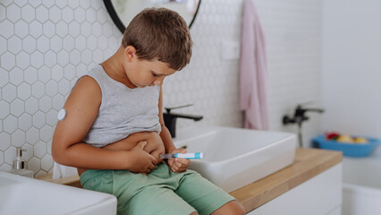Fototapeta premium Little boy with diabetes injecting insulin in his belly.
