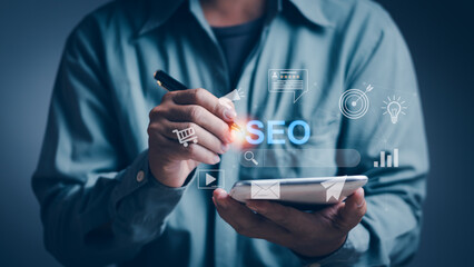 Businessman holds a pen and uses a tablet Manage SEO system for online marketing strategies, concepts Manage customer information on the website or search engine optimization technology