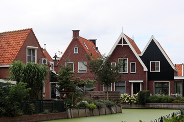 Classic Dutch houses on a street. Cute buildings with red tiles roof. Architecture of the Netherlands. 