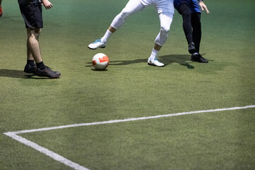 Obraz premium Futsal football players playing game in indoor stadium on artificial turf.