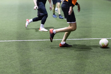 Fototapeta premium Futsal players with the ball on artificial grass field.