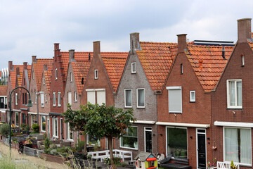 Fototapeta premium Classic Dutch houses on a street. Cute buildings with red tiles roof. Architecture of the Netherlands. 