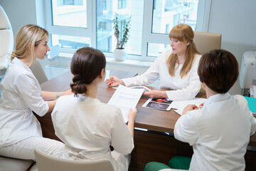 Obraz premium Female doctors in medical uniforms gathered for a medical consultation