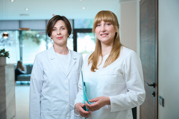 Fototapeta premium Women doctors stand in the hospital lobby at reception desk