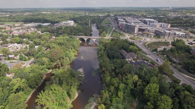 Aerial drone establishing view of Bridge Park businesses, roadway traffic, new restaurants, and hotels by the Scioto River in rich upper-class downtown Dublin, OH northwest of Columbus, Ohio