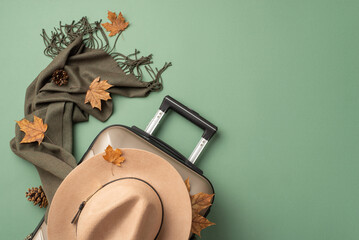 Fall foliage adventure: A top-view shot of autumnal outdoor exploration essentials featuring a cozy scarf, elegant hat, suitcase, vibrant maple leaves, and pine cones in a scenic green setting