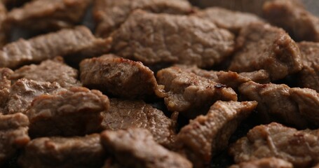 Sliced pieces of meat are fried in a frying pan. Roasting beef in a pan. Cooking in the kitchen. Food preparation. Close-up shot.