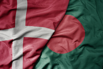 big waving national colorful flag of denmark and national flag of bangladesh .