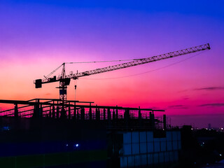 Large construction site including several cranes background Steel frame structure on a building sunset